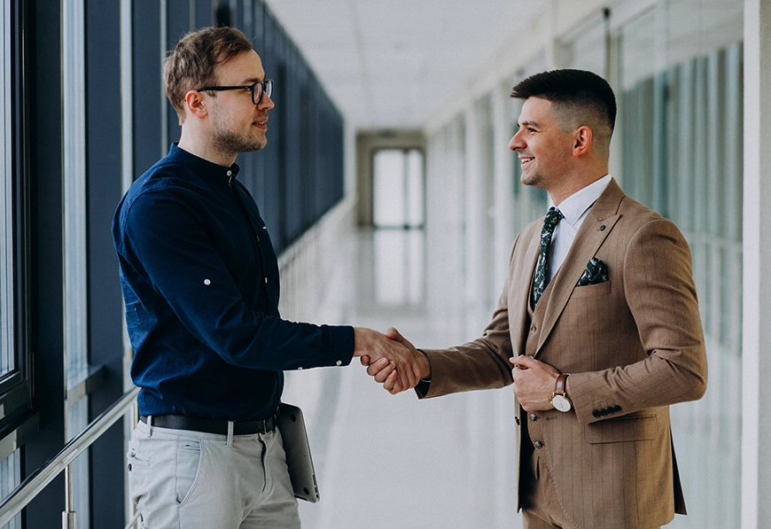 AIBN handshake in modern corridor, symbolizing collaboration and business connection.