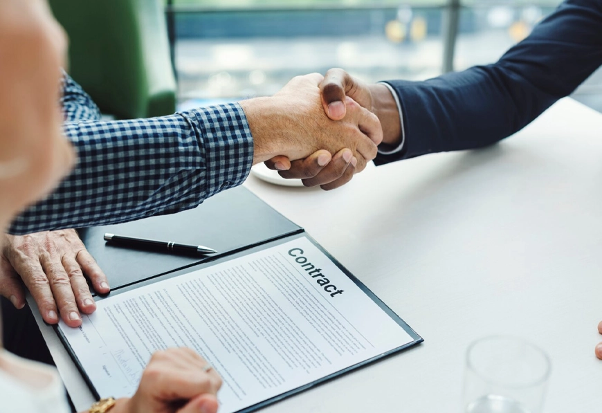 AIBN handshake over contract symbolizing strategic alliance and joint venture.