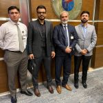 A group of business professionals from AIBN and the Pakistan Armed Forces are at a meeting, symbolizing a partnership.