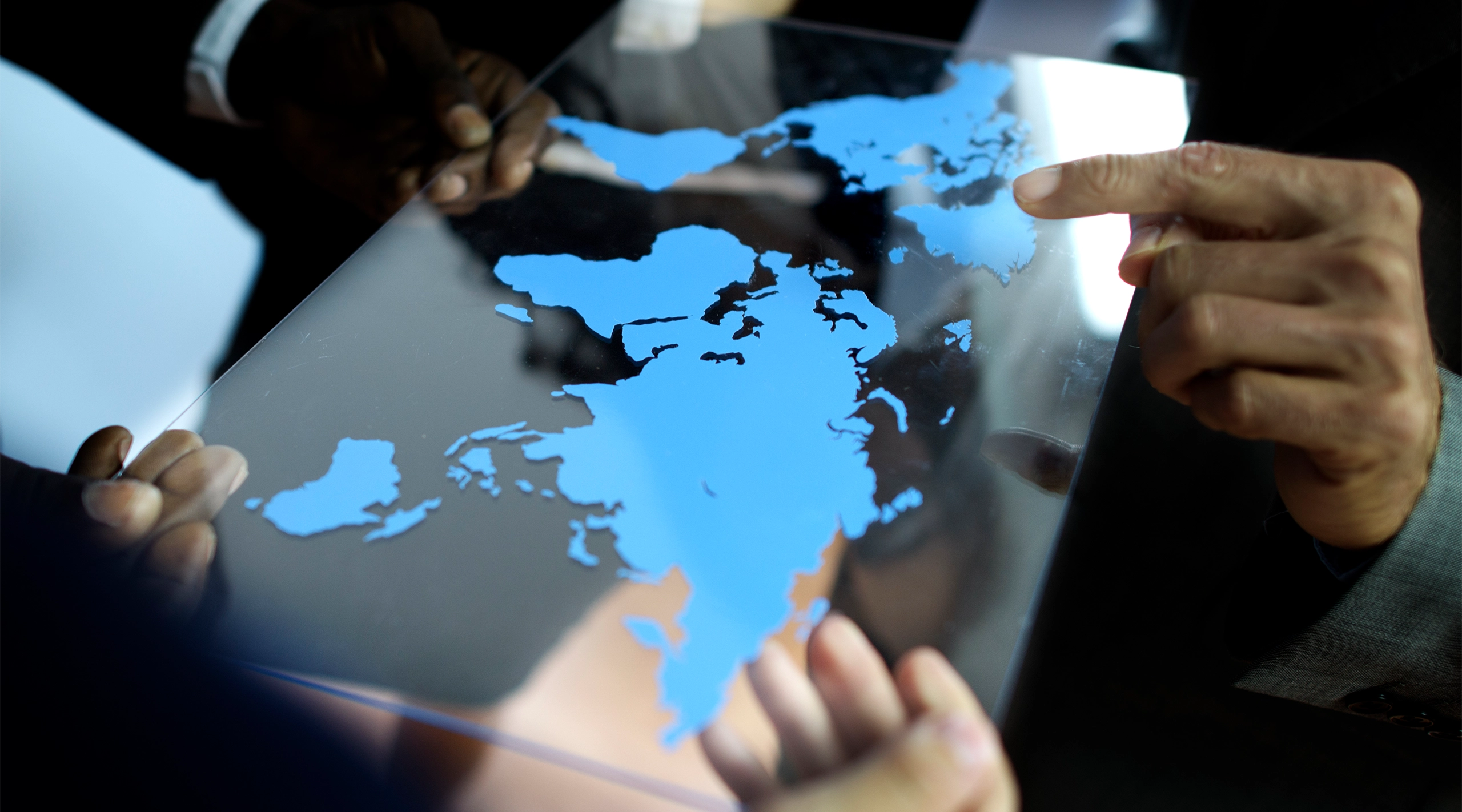 Two hands holding a holographic map of the world, representing AIBN's global business growth support.