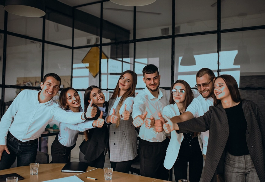AIBN team giving thumbs-up in office, symbolizing celebration, teamwork, and event success.