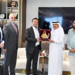 A group of business professionals from AIBN and the Sialkot Chamber of Commerce & Industry are presenting a trophy to a Qatari official, symbolizing a new strategic partnership.