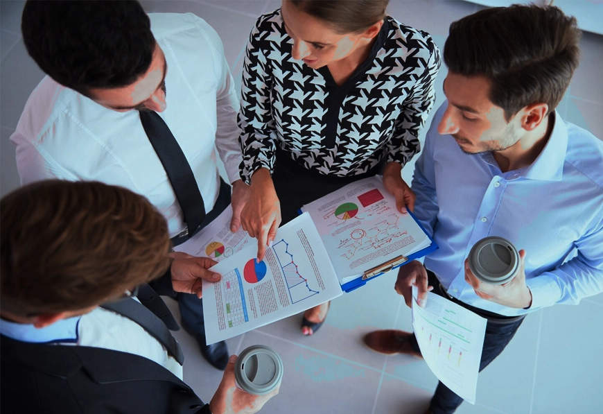 AIBN professionals discussing charts and graphs, symbolizing teamwork and strategic analysis.