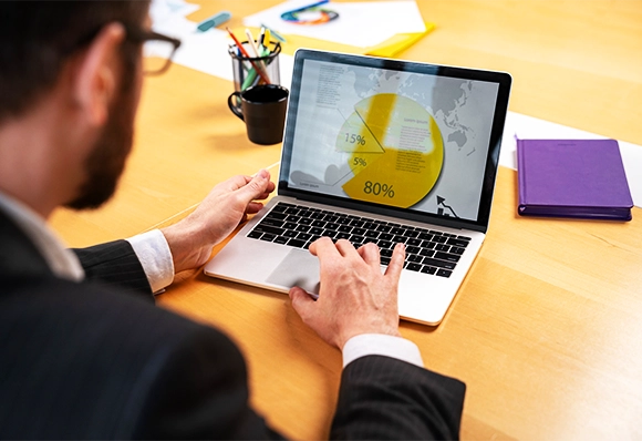 An AIBN team member analyzing market data on a laptop.