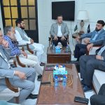 A group of business professionals from AIBN and the Sialkot Chamber of Commerce & Industry (SCCI) are in a business meeting, symbolizing a strategic partnership.