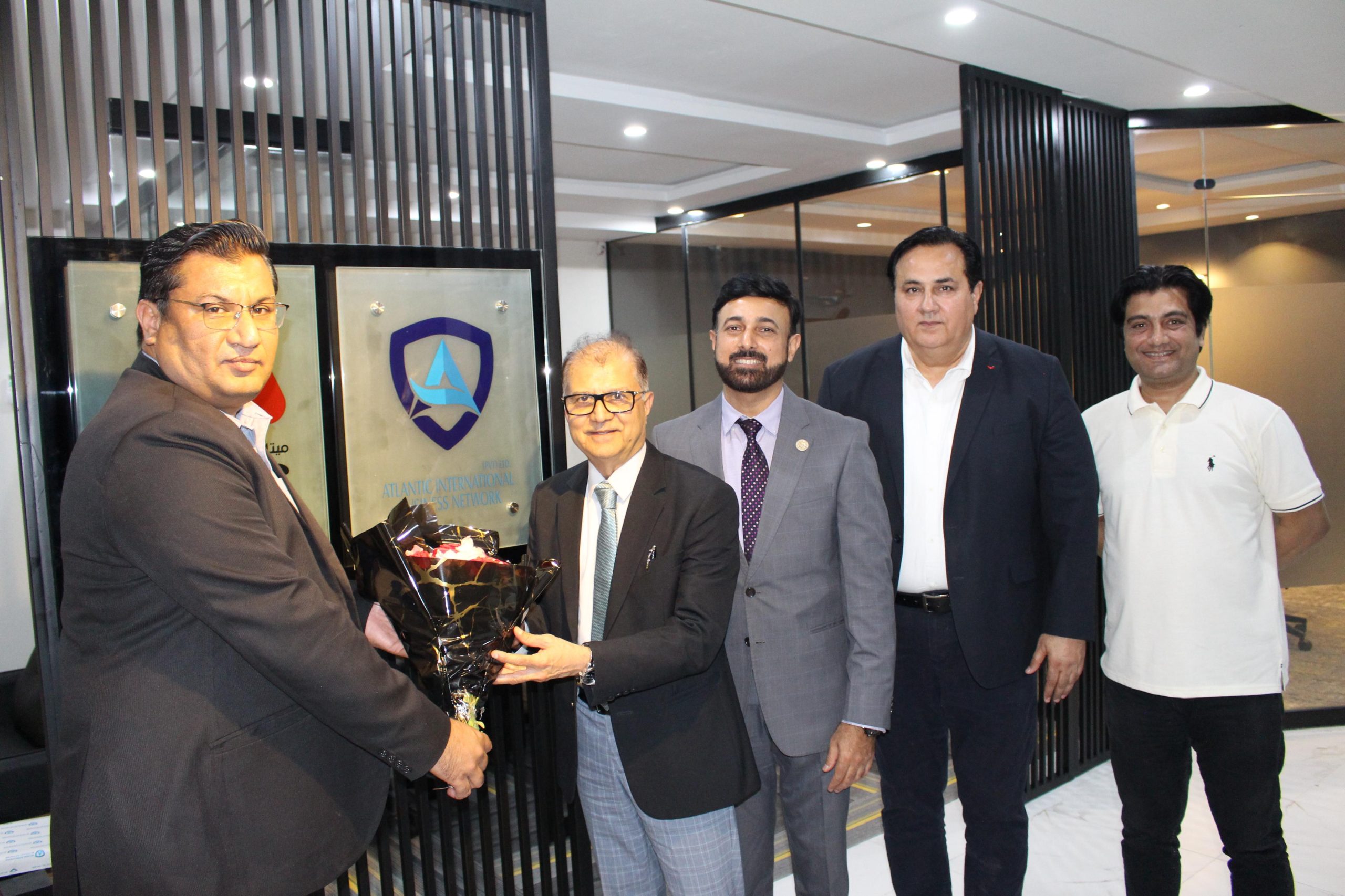 The AIBN team presenting flowers to a guest.