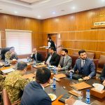A group of business professionals from AIBN and the Pakistan Armed Forces are in a business meeting, symbolizing a strategic partnership.